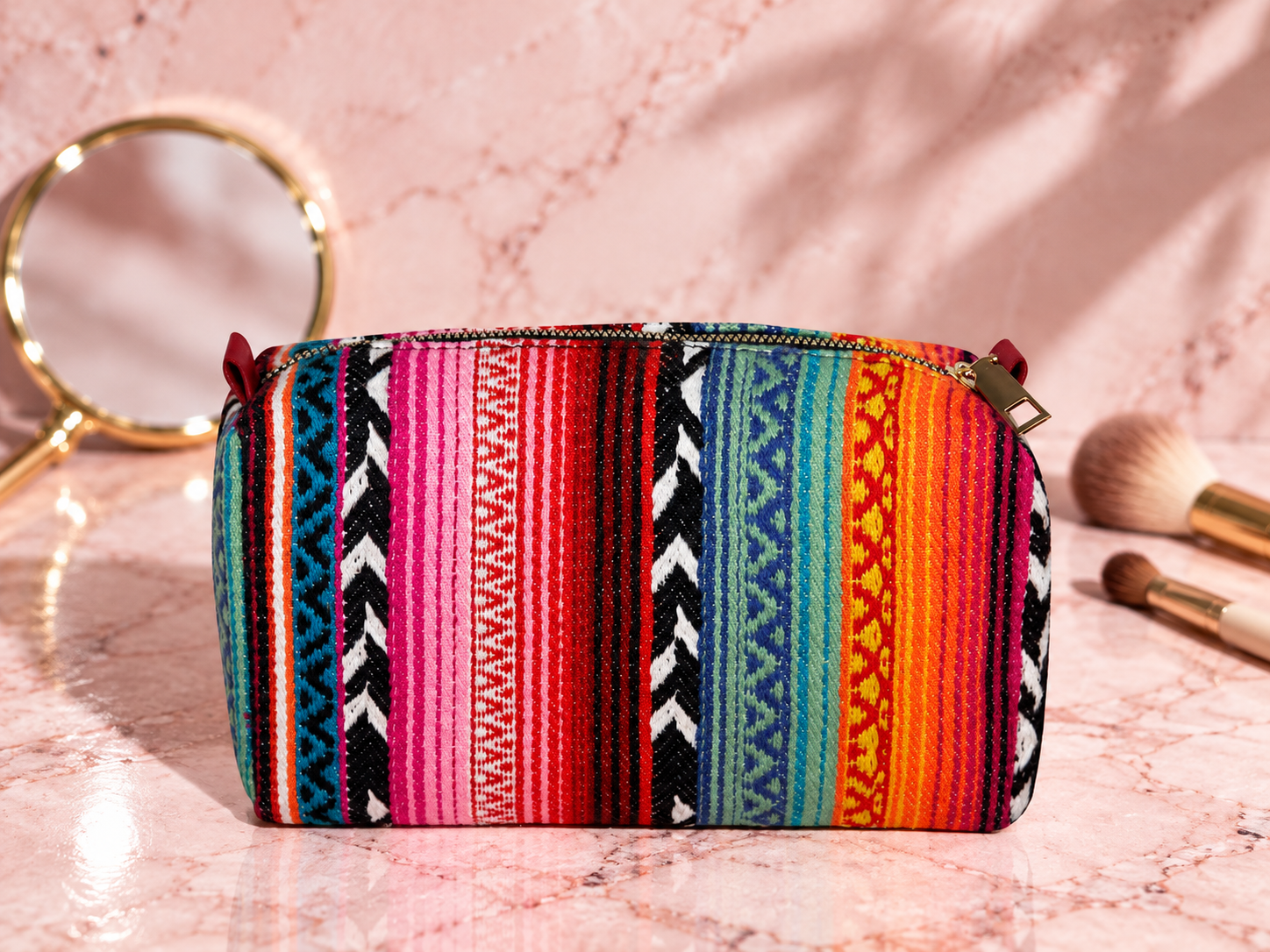 The Store's multicolor woven travel makeup pouch in an original vanity still life